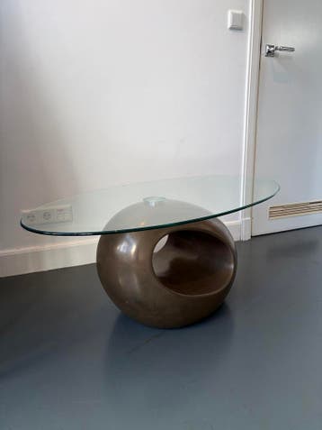 Moderne salontafel met glazen blad en unieke voet