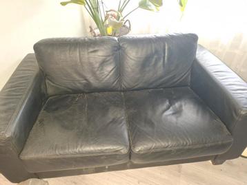 2 zwarte leren banken en salontafel
