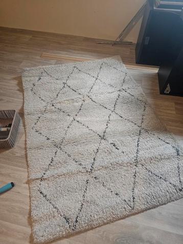 Zacht crèmekleurig vloerkleed met zwart ruitpatroon