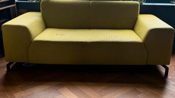 Gele 2-zitsbank met gebruikssporen