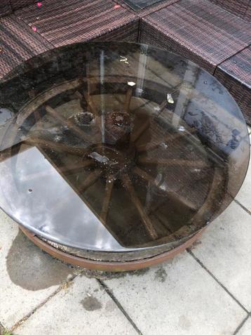 Unieke tuintafel van oud wagenwiel met glazen blad
