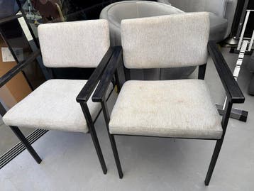 Twee stoelen met lichte bekleding en donker frame