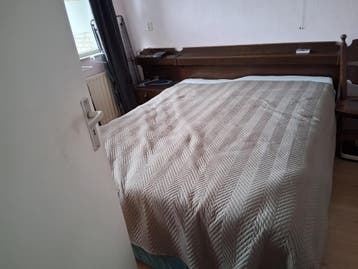 Tweepersoonsbed met houten ombouw en nachtkastjes