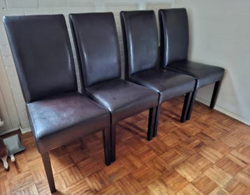 Vier donkerbruine lederen stoelen