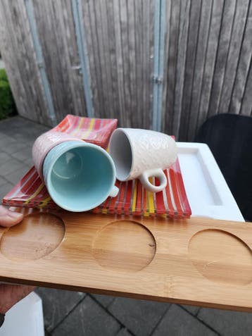 Kopjes en schaaltjes met houten plank