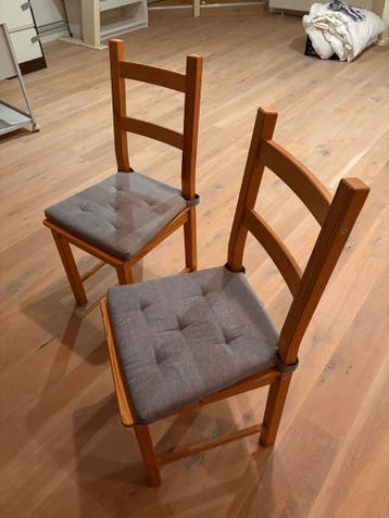 Twee houten stoelen met kussens