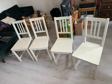 Grats vier witte houten eettafelstoelen, één is stuk