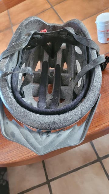 Twee fietshelmen een grijs een rood zwart