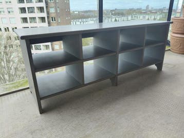 Grijze lage kast met open vakken