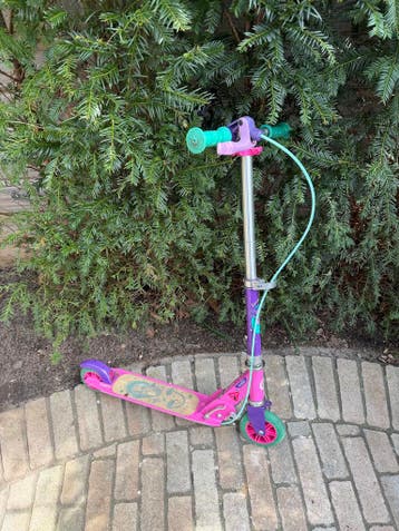 Roze step met groene wielen