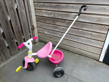 Roze driewieler met duwstang