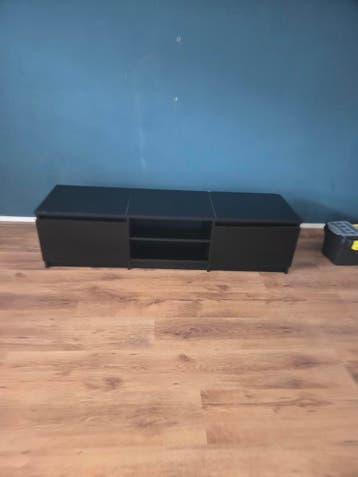 Zwarte tv-kast met kleine beschadigingen