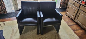 Twee donkerbruine leren fauteuils