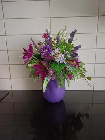 Paarse vaas met kunstbloemen