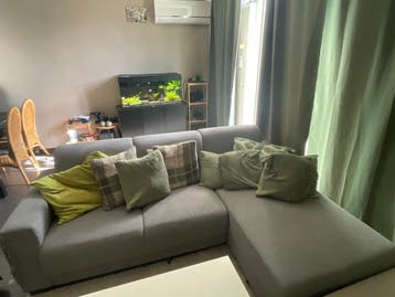 Grijze hoekbank met beschadigde armleuning