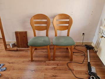 Twee houten stoelen met groene zitting