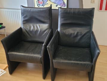 Twee zwarte leren stoelen / fauteuils met armleuningen