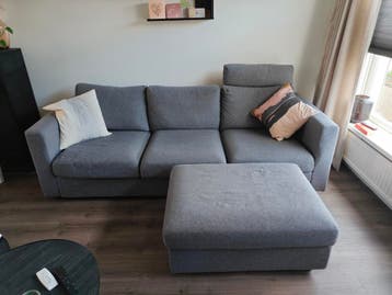 Gratis grijze 3-zits bank met losse poef