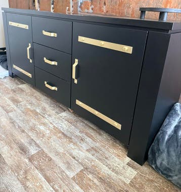 Zwart dressoir met goudkleurige handgrepen