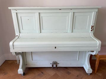 Oude piano, mintgroen geschilderd, moet gestemd worden