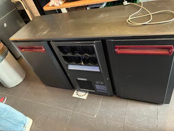 Grote defecte koelkast met flessenrek