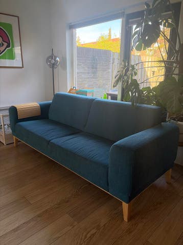 Blauwe stoffen bank met houten poten