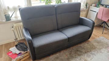 Grijze tweezitsbank met zwarte armleuningen