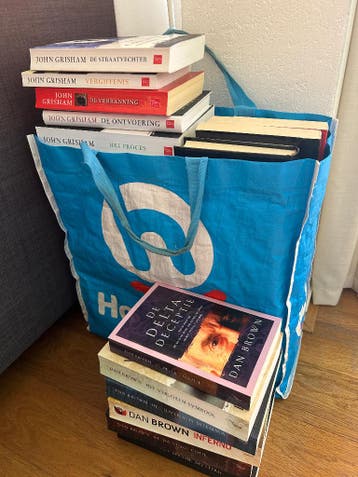 Tas vol boeken van Dan Brown en John Grisham