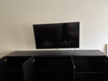 Zwarte tv-kast met goudkleurige rand