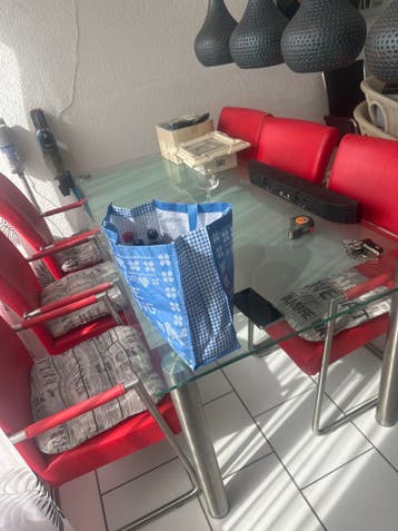 Glazen eettafel met 6 rode stoelen