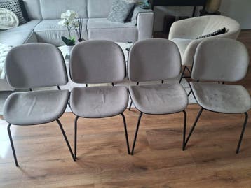 Vier taupe stoelen met zwarte poten