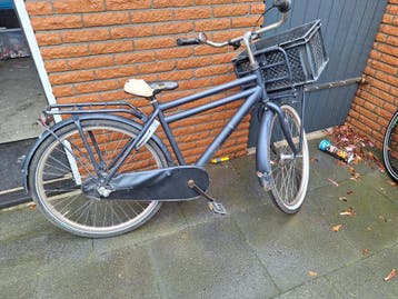 Gebruikte stadsfiets met voordrager en mand
