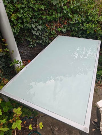 Eettafel met stalen frame en melkglazen blad