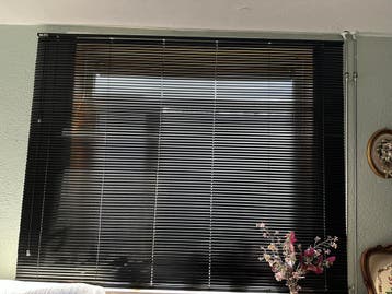 Zwart rolgordijn met defect verstelmechanisme