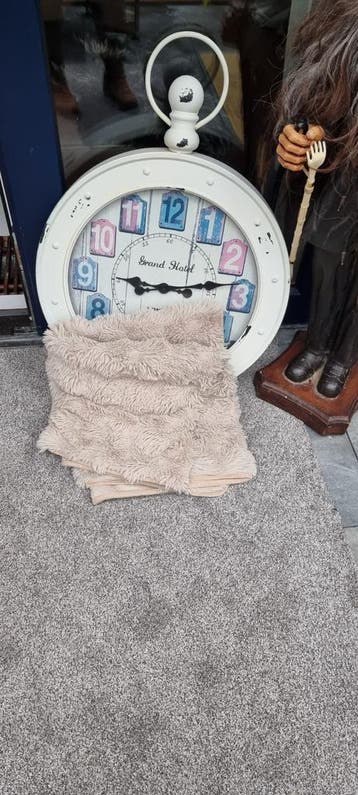 Grote klok en zacht kleed voor op de bank