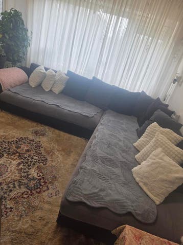 Grote hoekbank met donkere kussens