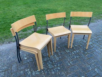 Vier houten stoelen met metalen onderstel