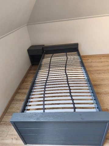 Grijs bed en nachtkastje