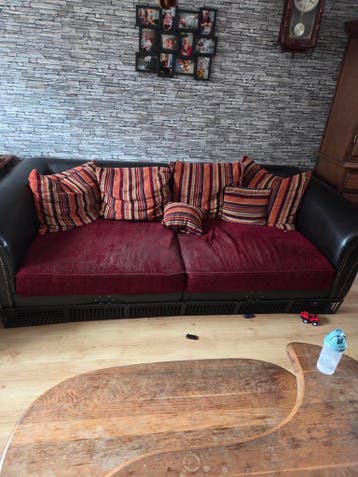 Gratis bank met rode en gestreepte kussens