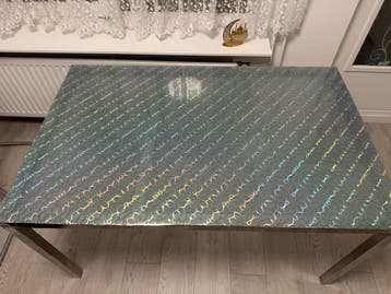 Eettafel met glazen blad en metalen onderstel