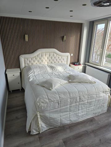 Luxe tweepersoonsbed met gestoffeerd hoofdbord