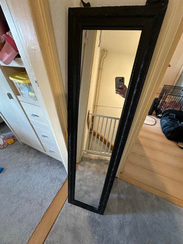 Zwarte spiegel met bewerkte lijst