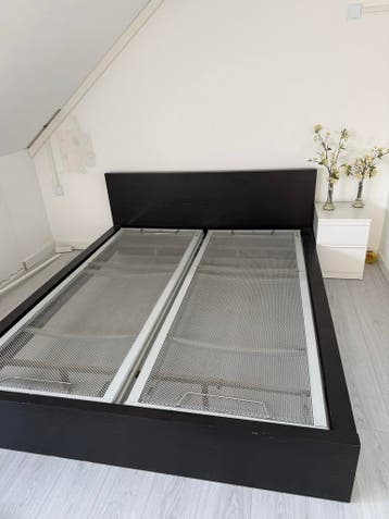 Zwart tweepersoonsbed met bodems
