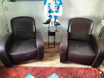 Twee donkerbruine leren stoelen