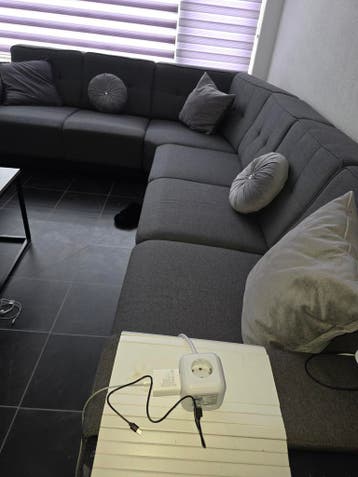 Grijze hoekbank met lichte kattenkrassen