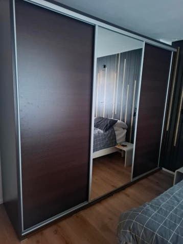 Ruime kledingkast met schuifdeuren en spiegel