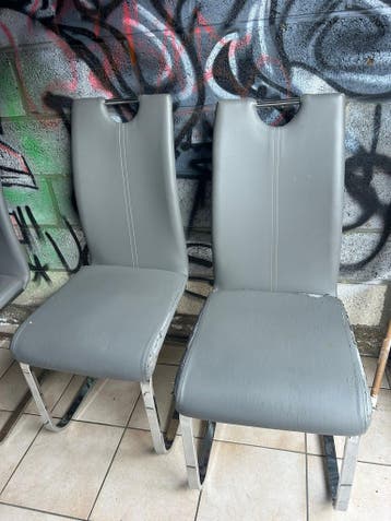 Zes grijze stoelen met metalen onderstel