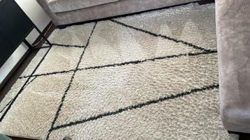 Modern wit tapijt met zwart geometrisch patroon