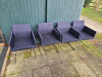 Vier donkerblauwe stoelen met metalen onderstel