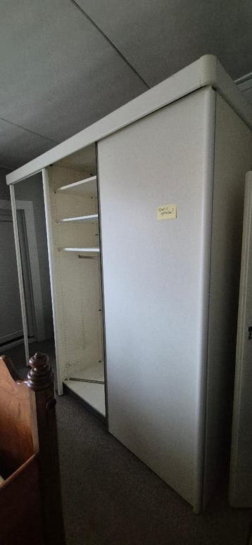 Ruime kledingkast met schuifdeuren en spiegel